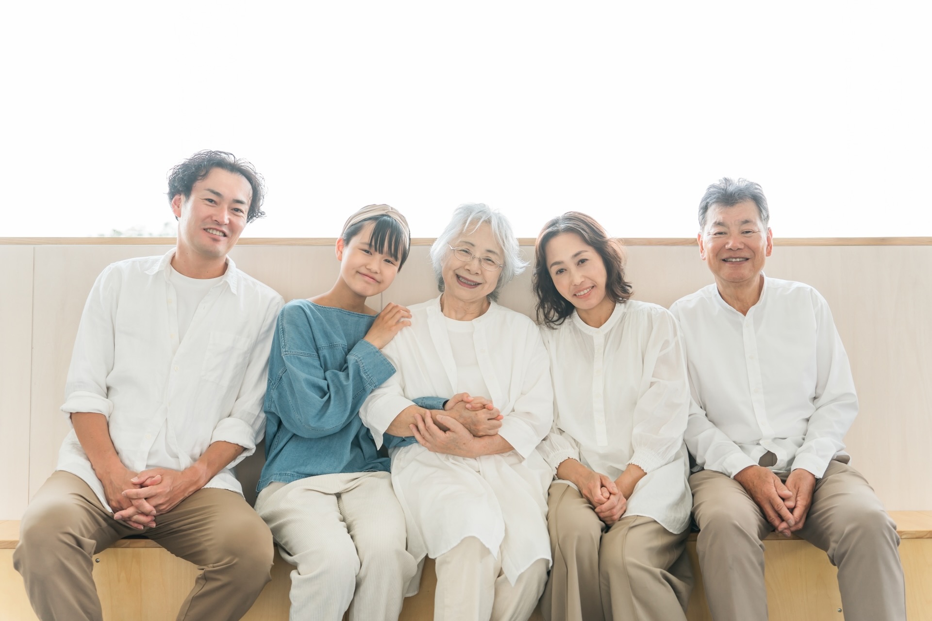 3世代のご家族が並んで笑顔で座っている様子